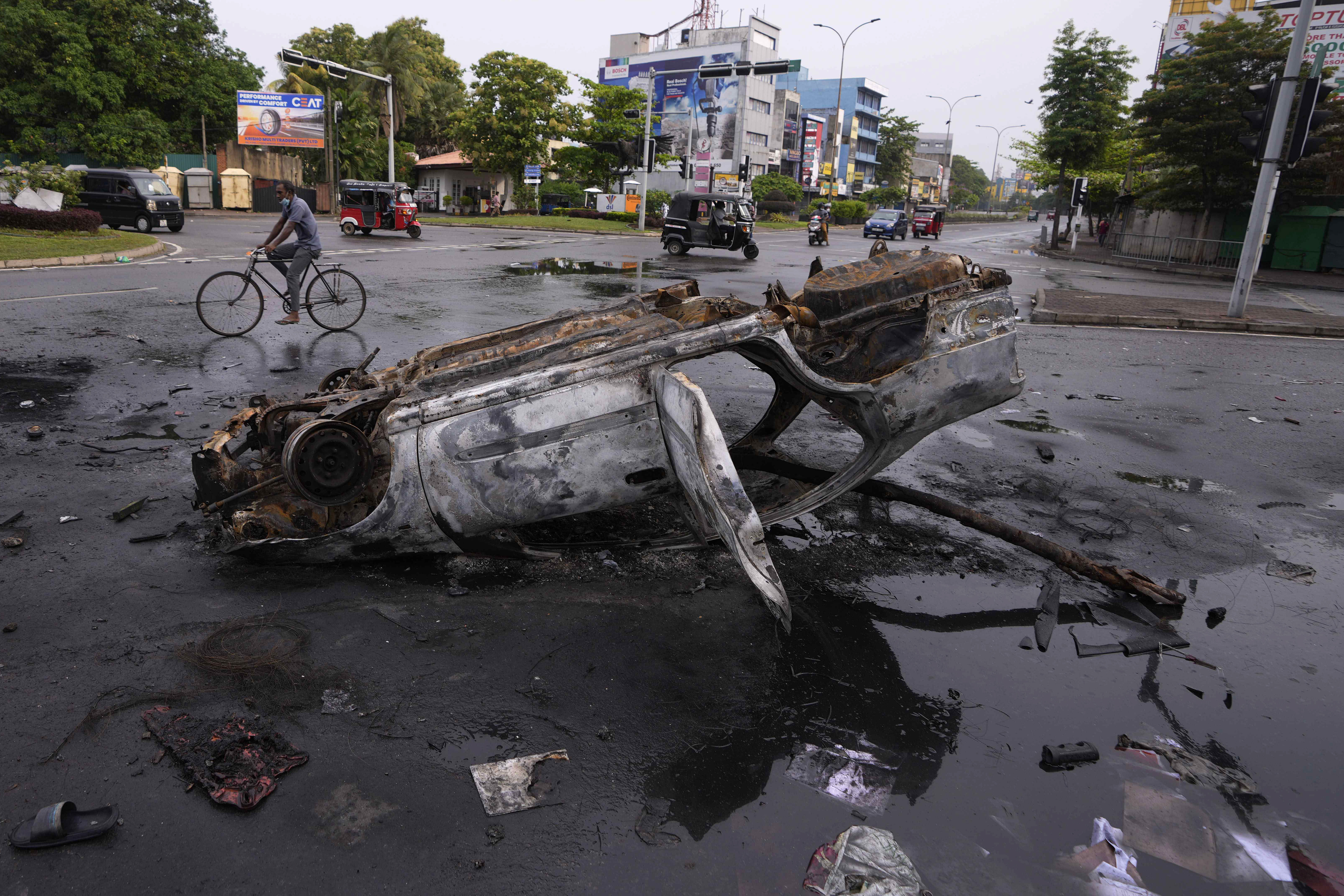 A burnt car lies at an intersection a day after the clashes between government supporters and anti-government protesters in Colombo.