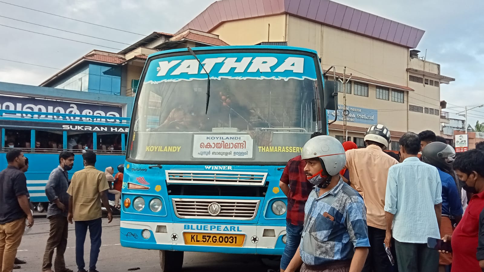 സ്‌കൂട്ടര്‍ ബസിനടിയില്‍ കുടുങ്ങി  ബസ് അപകടം  യുവാവിന് അത്ഭുത രക്ഷപ്പെടല്‍  കൊയിലാണ്ടിയില്‍ ബസ്സപകടം