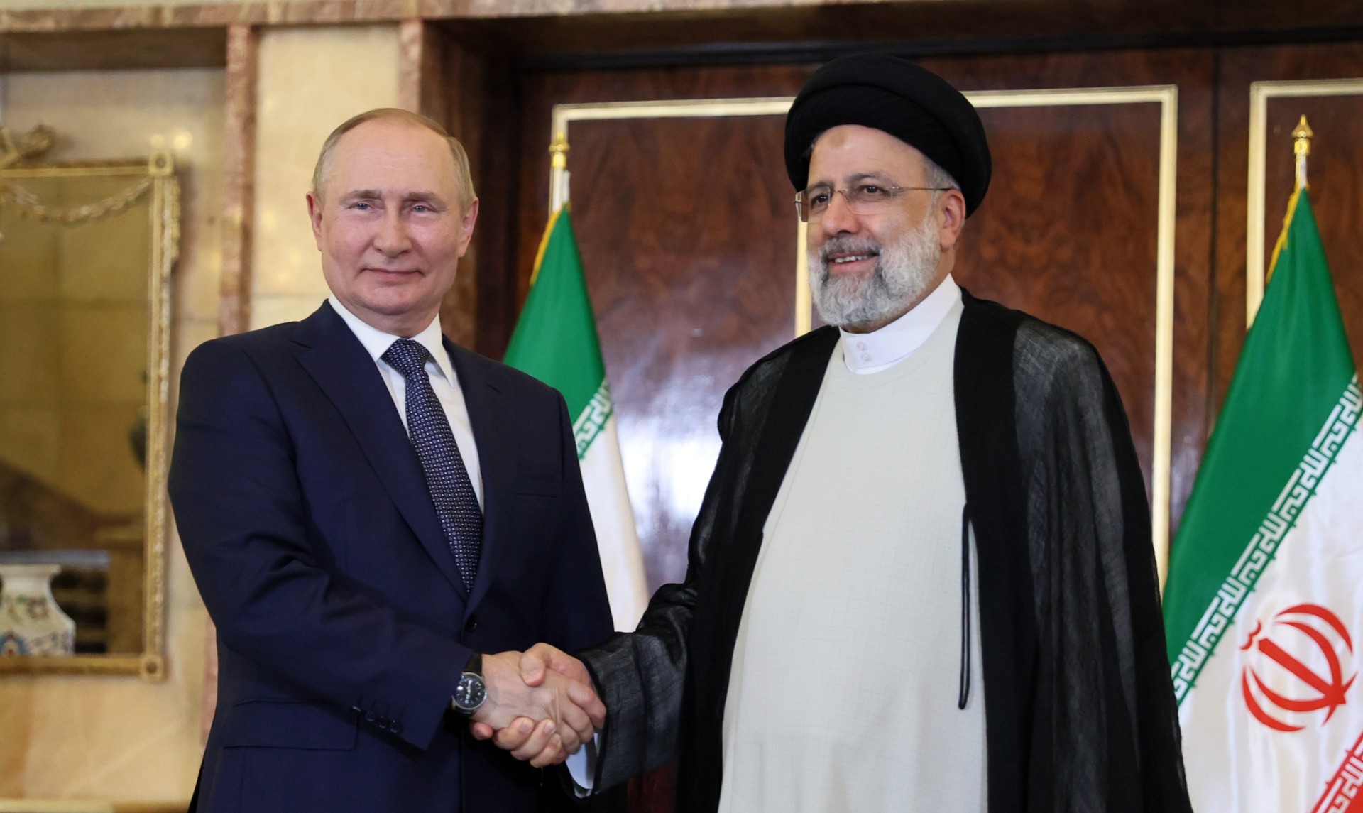 Iranian President Ebrahim Raisi shaking hands with Russian President Putin