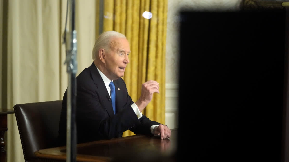 As seen through a window from the Colonnade outside the Oval Office, President Joe Biden speaks during his farewell address at the White House in Washington, Wednesday, Jan. 15, 2025.