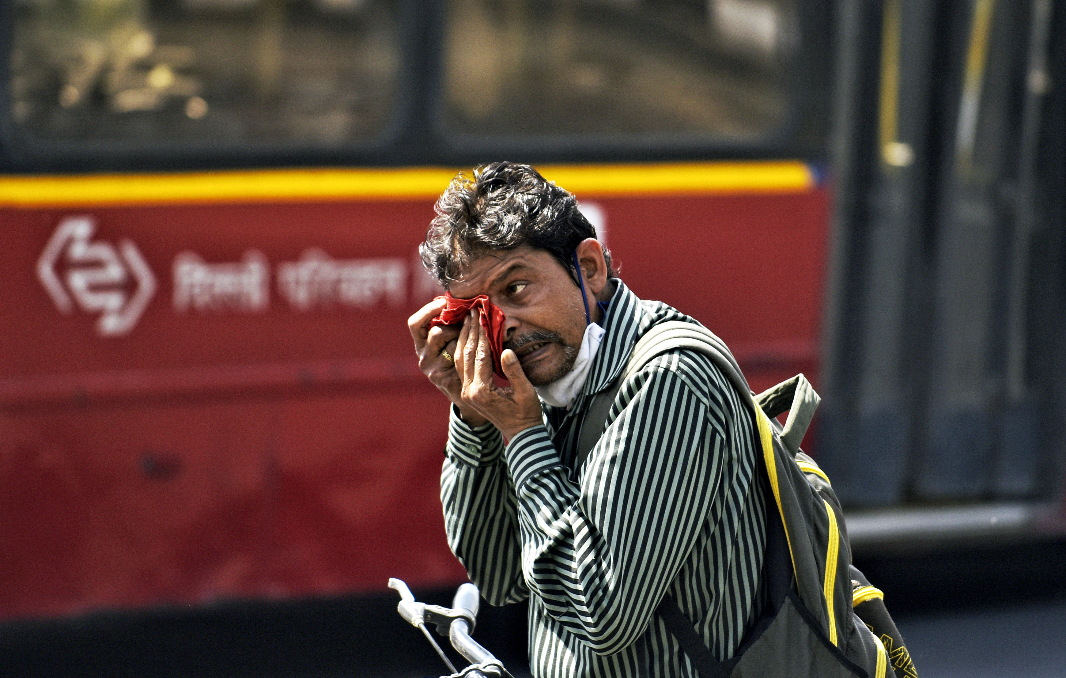 A man wipes sweat on his face during the heatwave in New Delhi