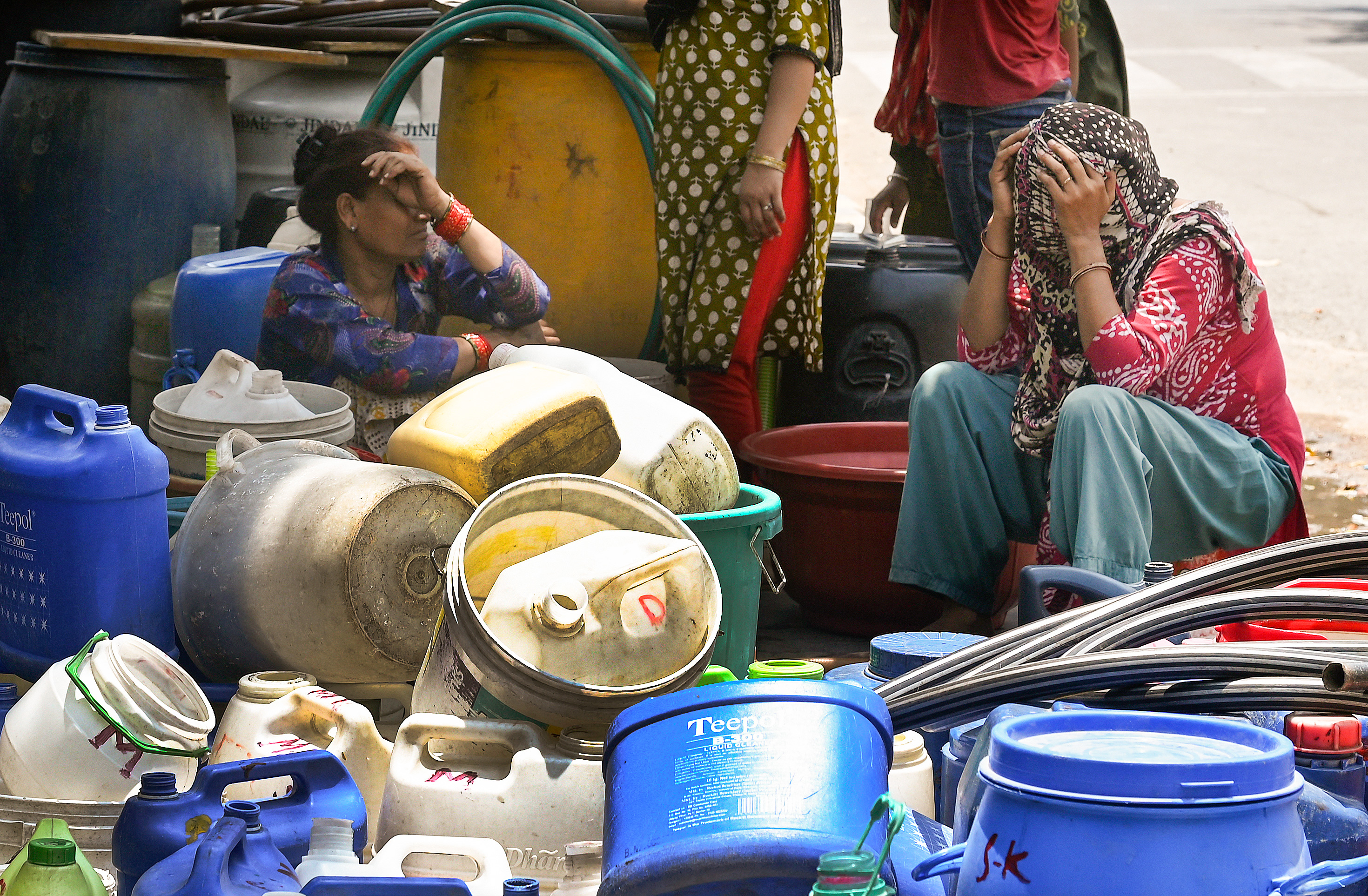 People with their buckets and gallons wait to collect drinking water from the New Delhi Municipal Council (NDMC) water tanker after the Swami Vivekananda Camp Chanakyapuri area faces a water crisis amid heatwave