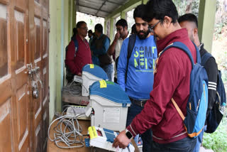 File photo of a polling officer looking at an EVM and VVPAT