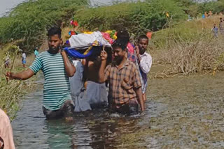 village near Dindigul due to lack of road facilities walk through waist deep water to bury the body