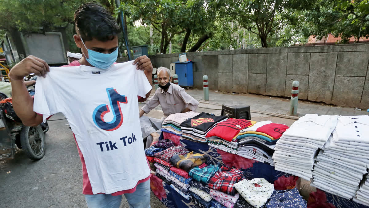 Customer tries T-shirt with the logo of Chinese based video sharing app Tiktok