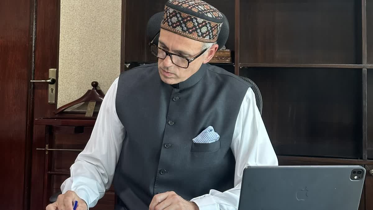 Omar Abdullah reviews a file after being sworn in as J&K CM