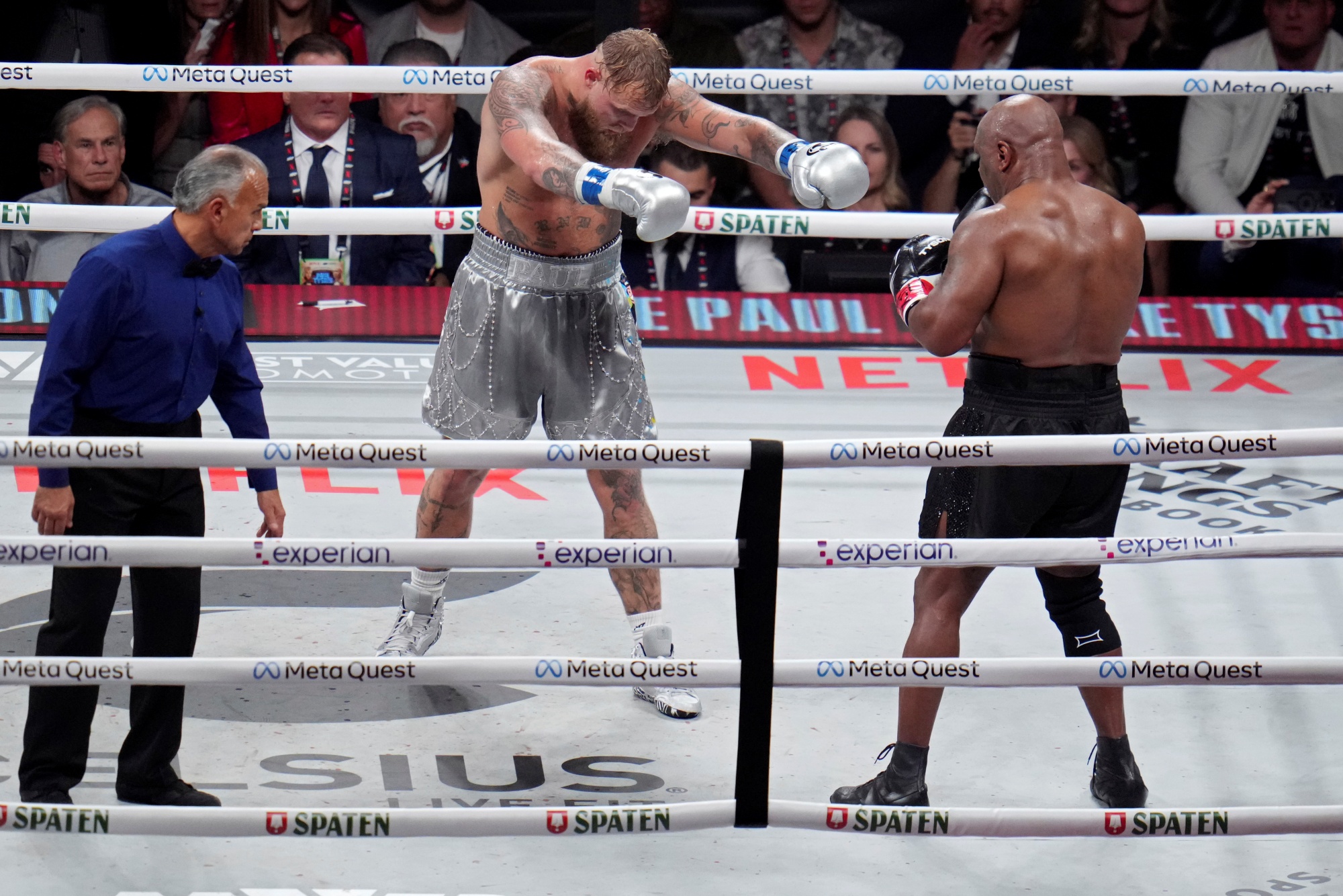 Jake Paul motions towards Mike Tyson during their heavyweight boxing match.