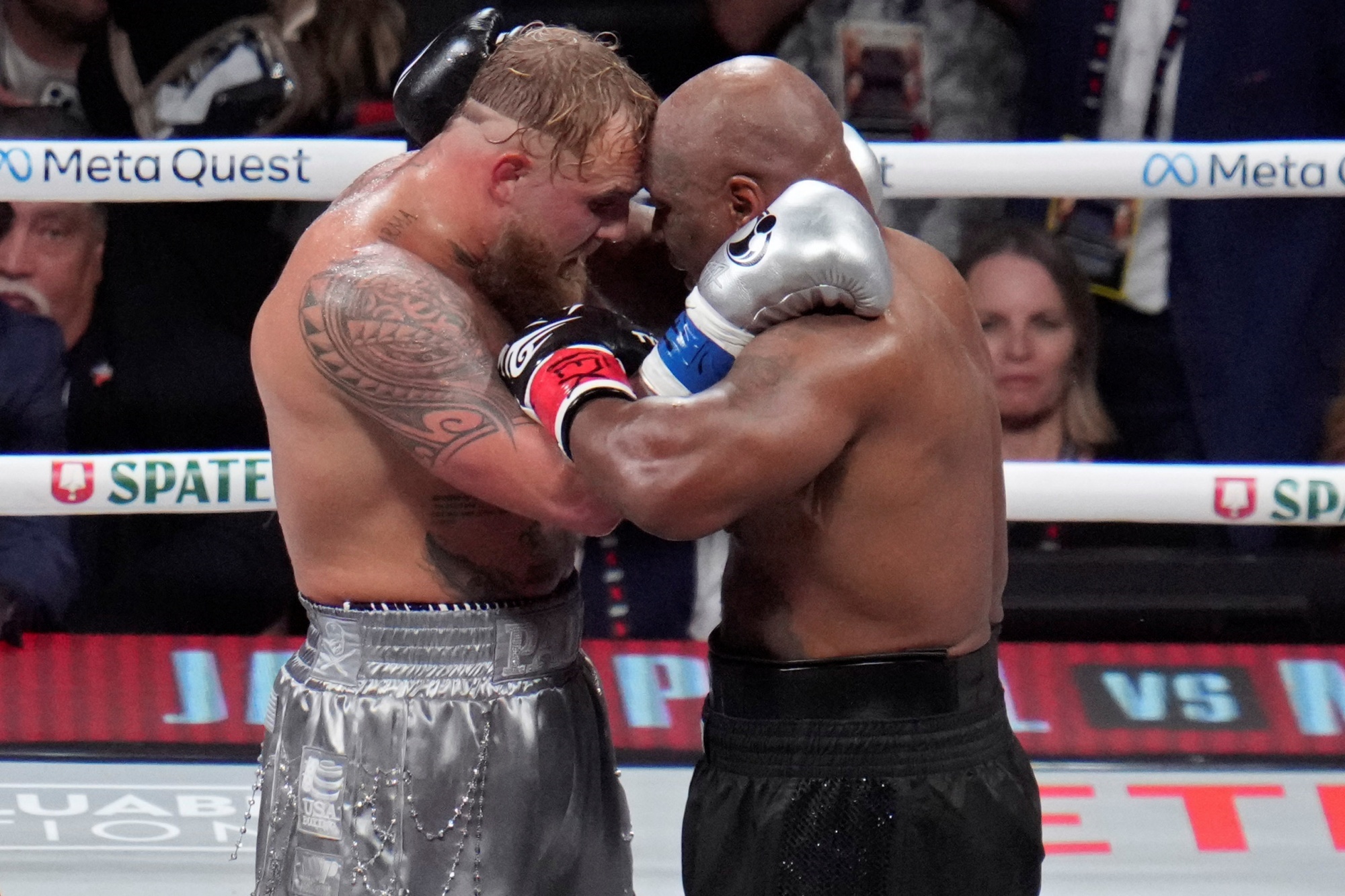 Jake Paul, left, and Mike Tyson embrace after their heavyweight boxing match.