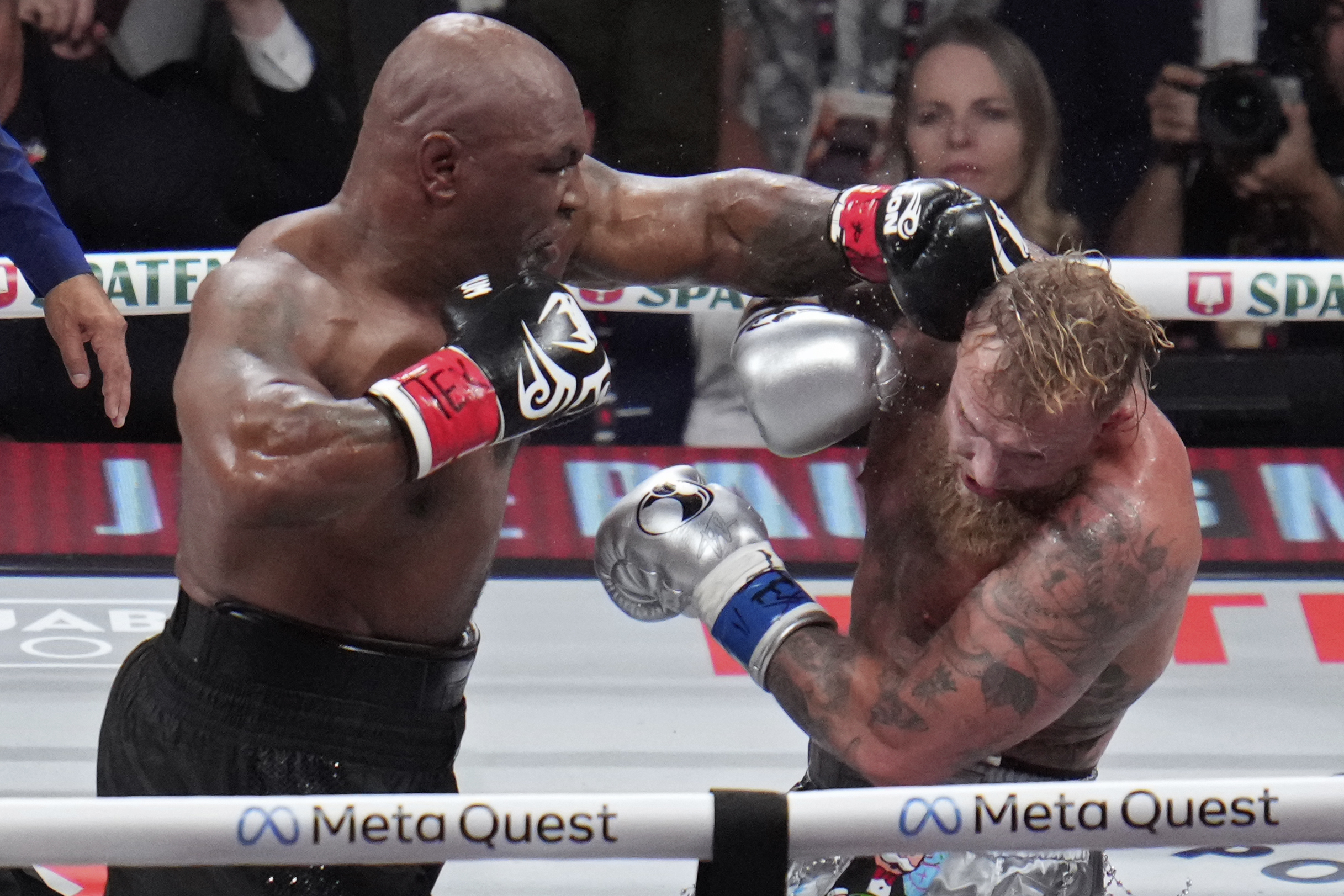 Mike Tyson hits Jake Paul during their heavyweight boxing match, Friday, Nov. 15, 2024, in Arlington, Texas.