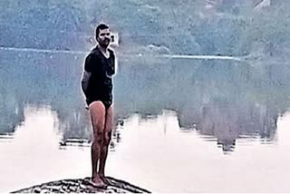 thief sits on rock in middle of pond