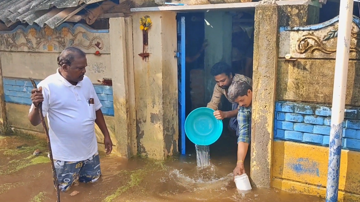 வீட்டிலிருந்து மழைநீரை வெளியேற்றும் மக்கள்