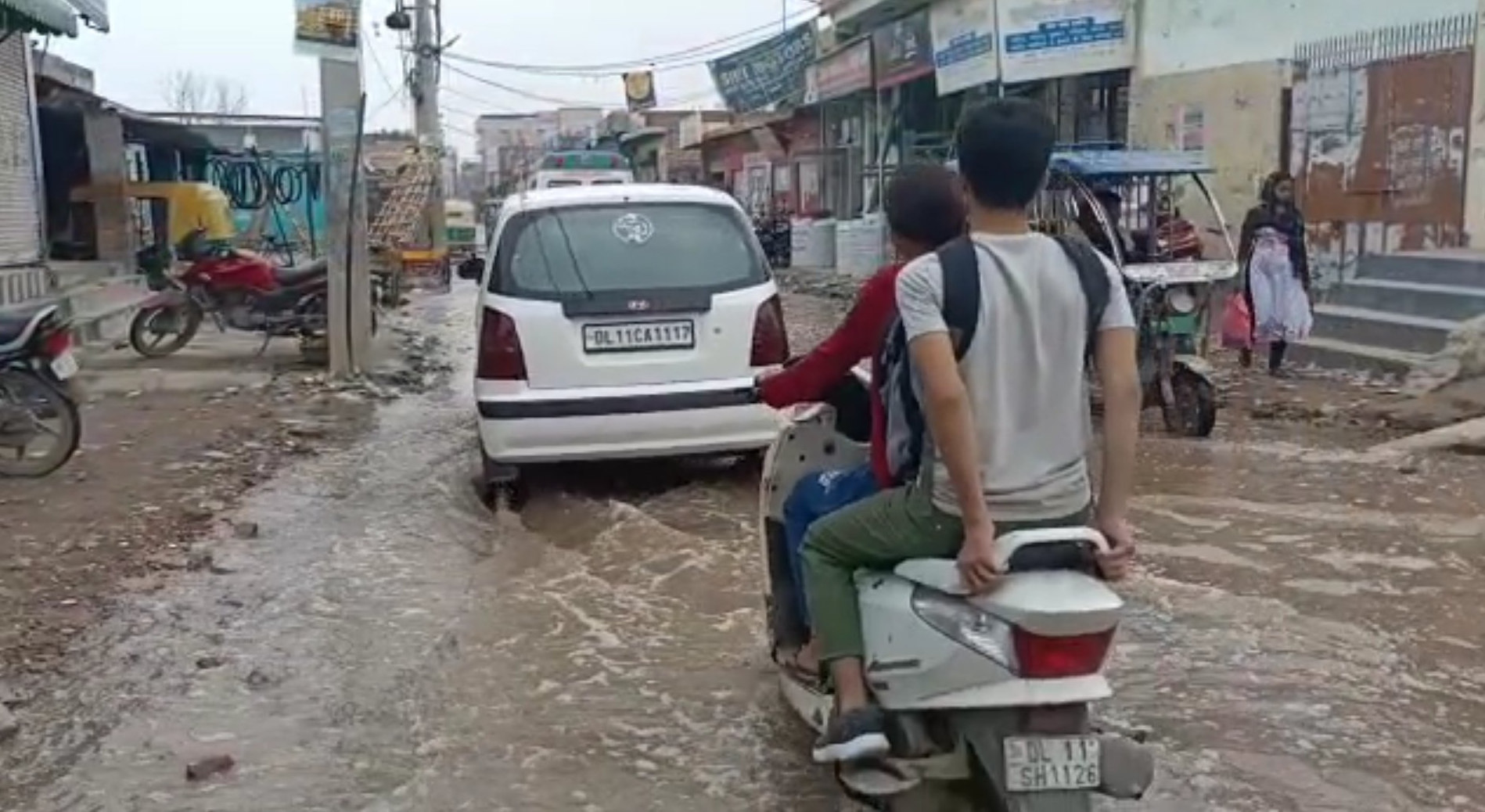 जलभराव के बीच गुजरती गाड़ियां.