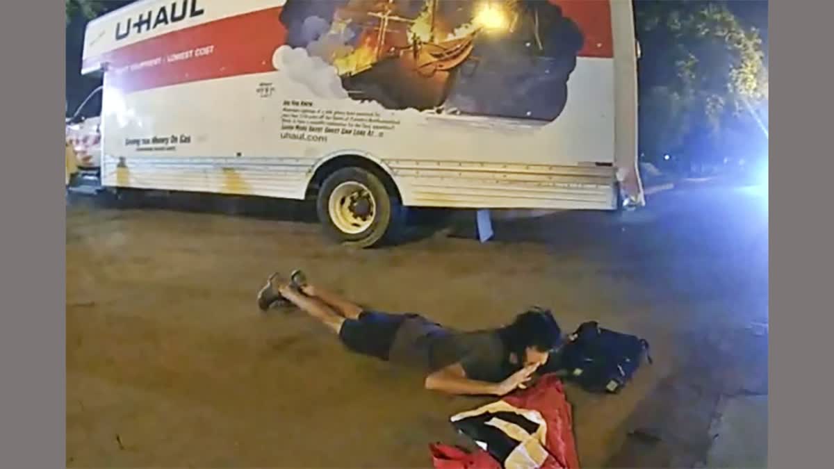 In this body camera image from video provided by the Justice Department in the government's sentencing memo, Sai Varshith Kandula is seen with a Nazi Flag once he was ordered down by the United States Park Police after nearly striking two people standing next to a park bench when he steered a U-Haul box truck onto a sidewalk and toward metal bollards that prevent vehicles from entering Lafayette Square, north of the White House, May 22, 2023, in Washington.