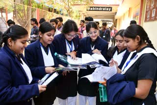 Examinees look at questions after the examination at a centre in Prayagraj.