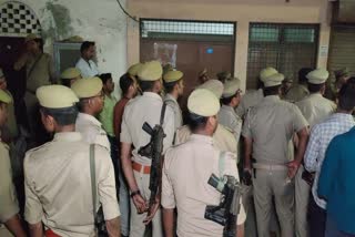 Cops gather outside a lodge where two cops found dead in UP