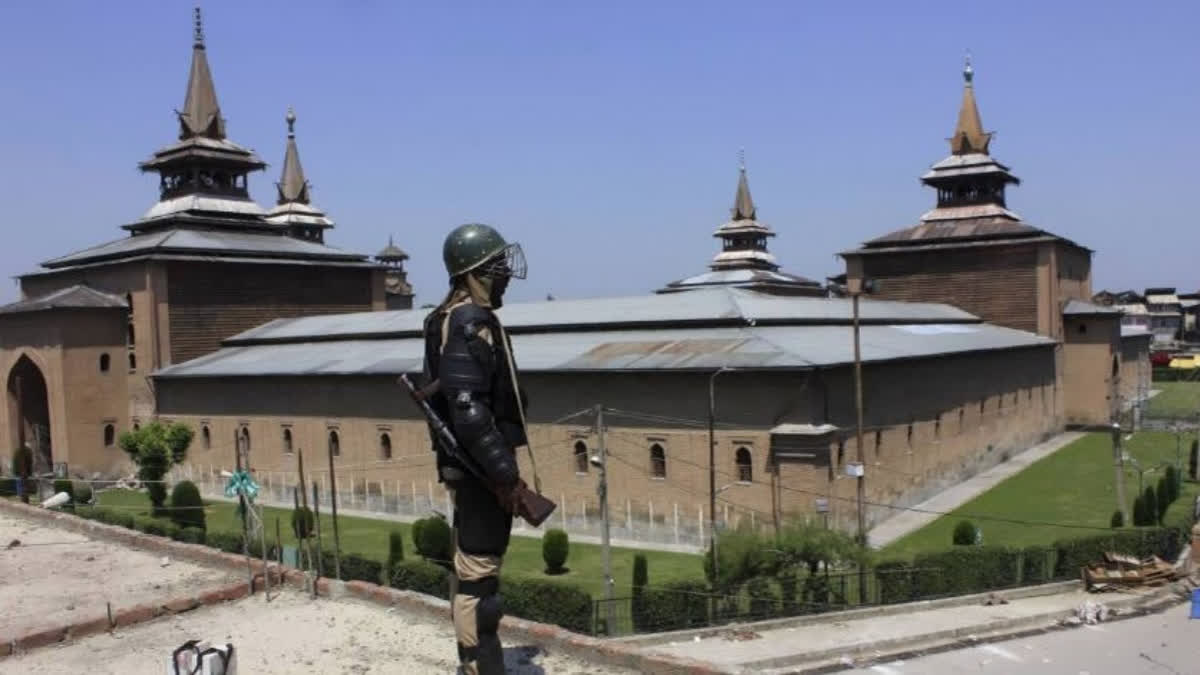 A security guard stands guard in front of Jamia masjid in Srinagar.