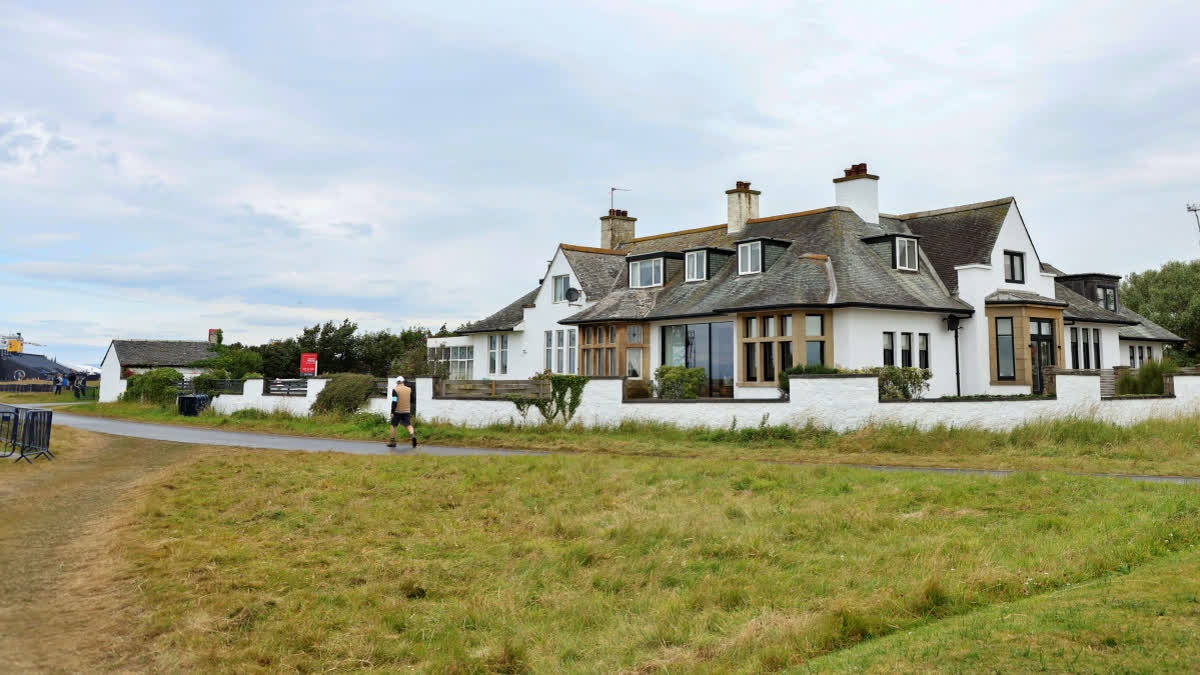 Spectators walk past "Blackrock house" that is listed for sale near the second and 16th holes at Royal Troon golf club, venue for the British Open Golf Championships, in Troon, Scotland, Tuesday, July 16, 2024.