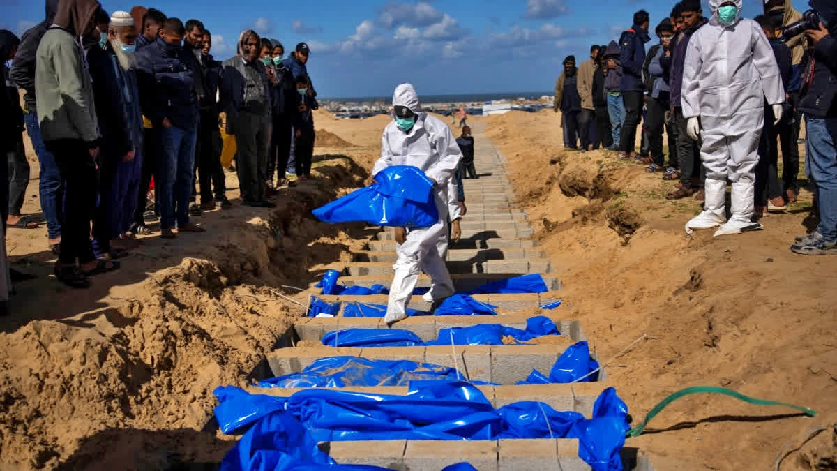 Palestinians bury bodies of people killed by Israel in Rafah.