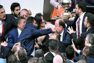 Turkey's ruling AK Party lawmakers scuffle with opposition lawmakers during the extraordinary session of the Turkish Grand National Assembly to debate the case of jailed opposition lawmaker Can Atalay, in Ankara, Turkey, Friday, Aug. 16, 2024.