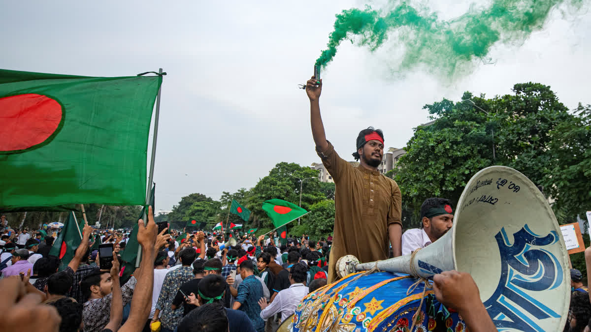 Students and other activists carry Bangladesh's national flag during a protest march