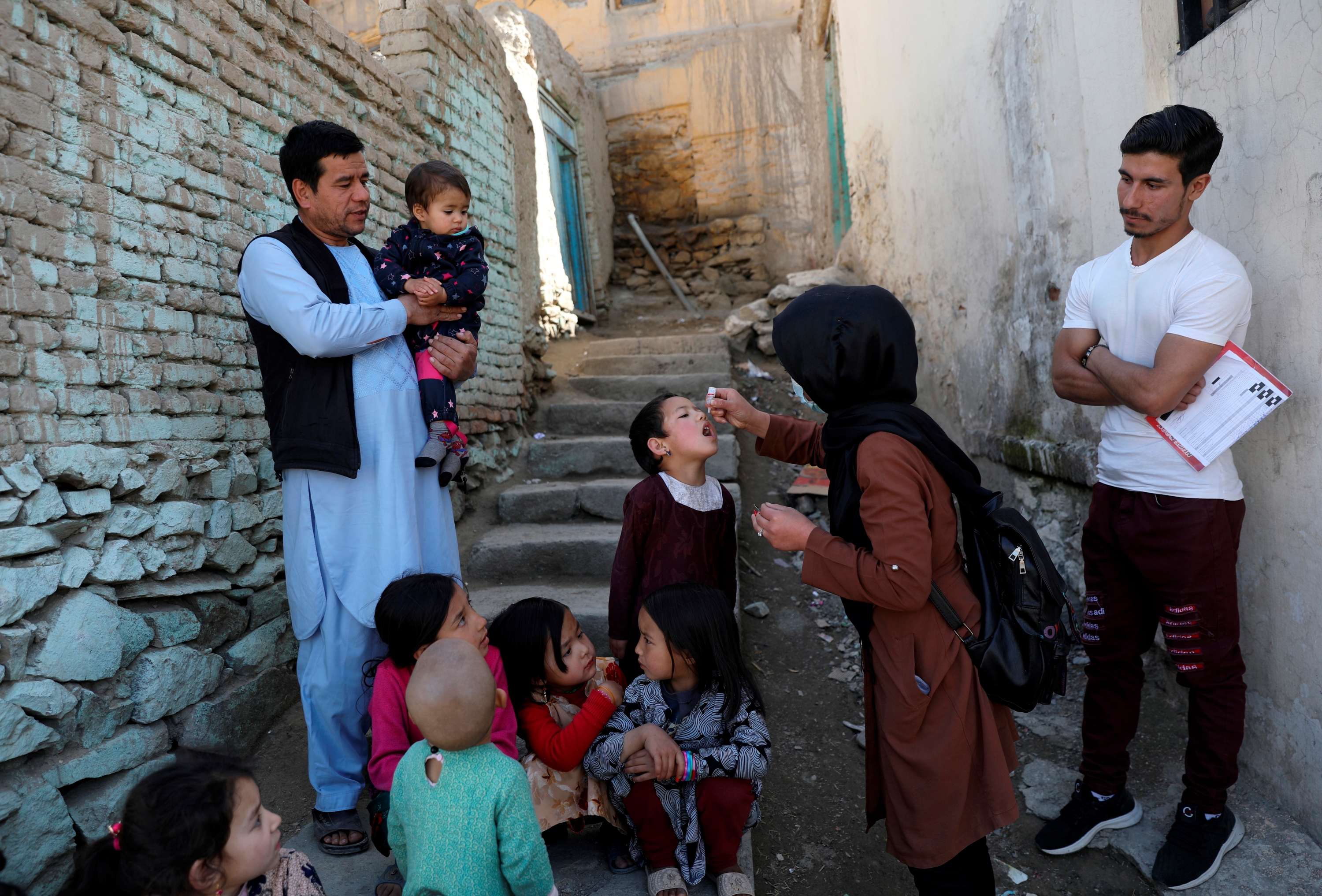 A worker gives polio vaccination to a child in the old part of Kabul, Afghanistan.