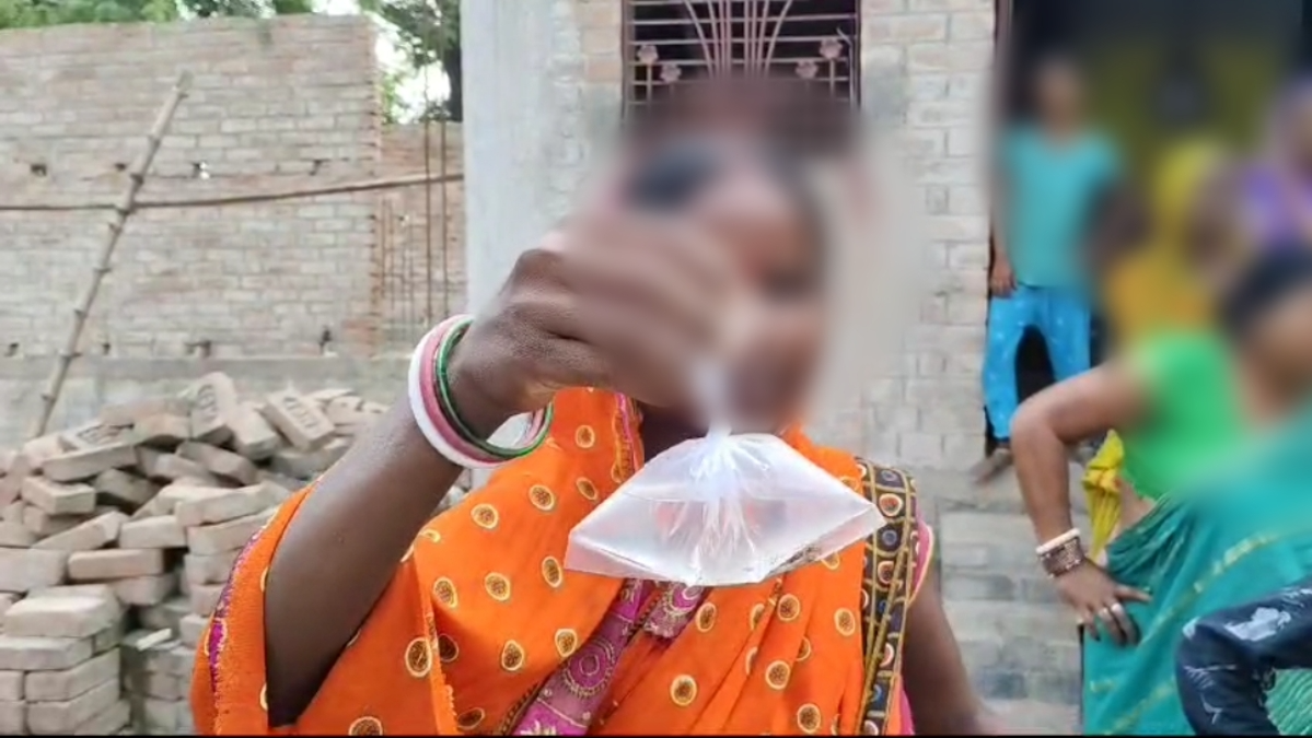 Women showing illicit liquor packet to media