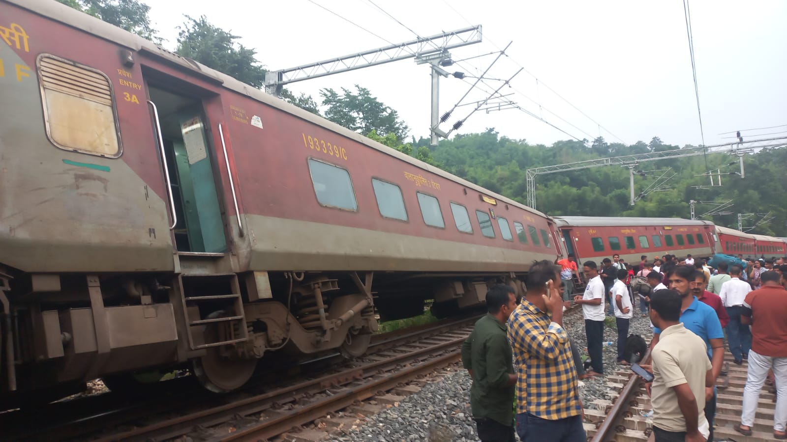 Locals gather near the derailed coaches in Haflong