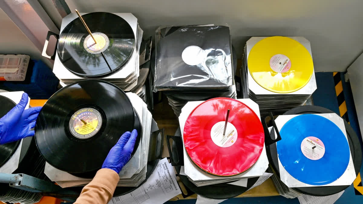 In this photograph taken on September 21, 2024, an employee arranges freshly stamped vinyl records at Samanvii Digimedia Art and Solutions pressing plant in Navi Mumbai.