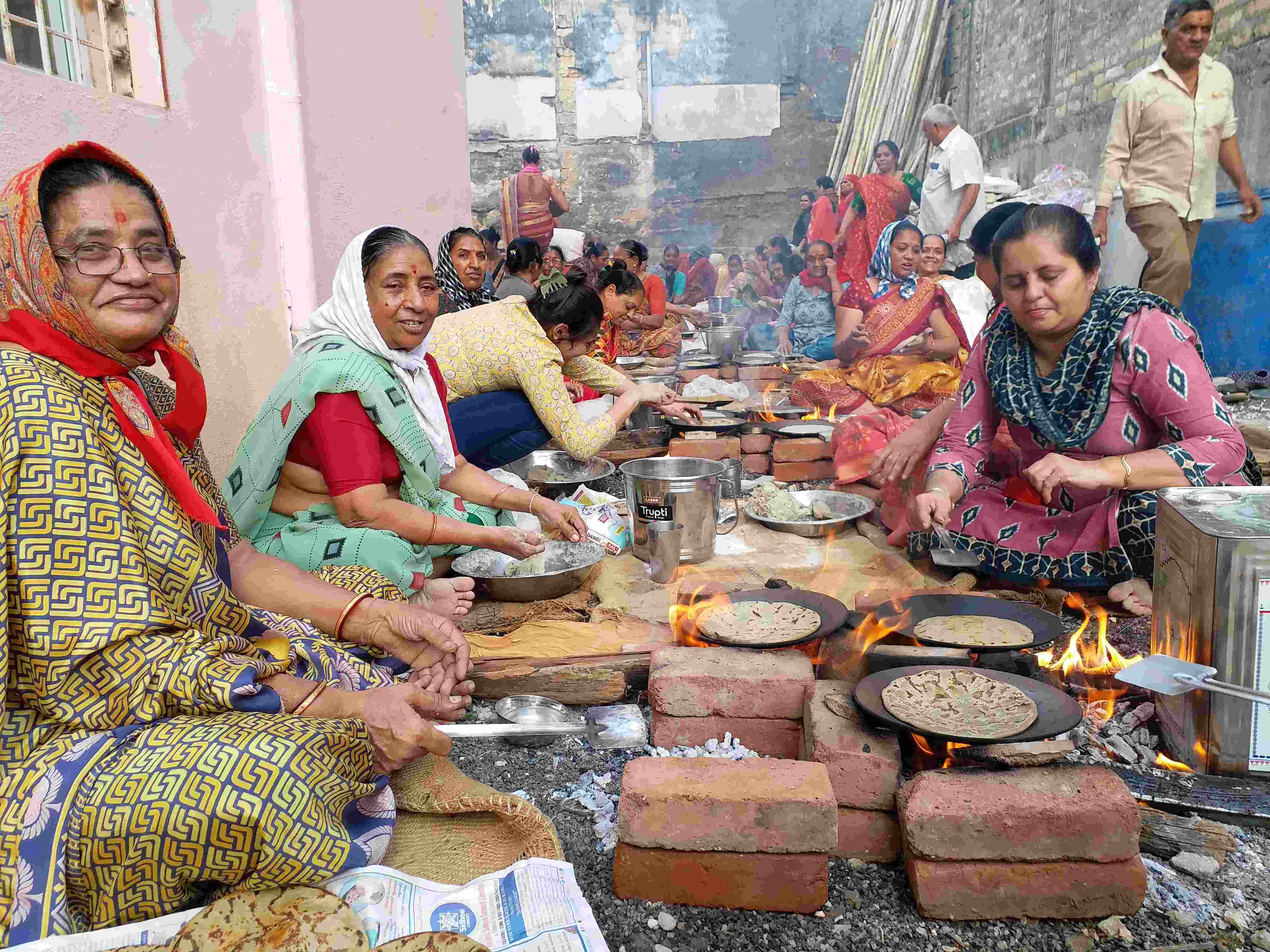 બાજરીના રોટલા બનાવતા સ્વયં સેવકો મહિલાઓ