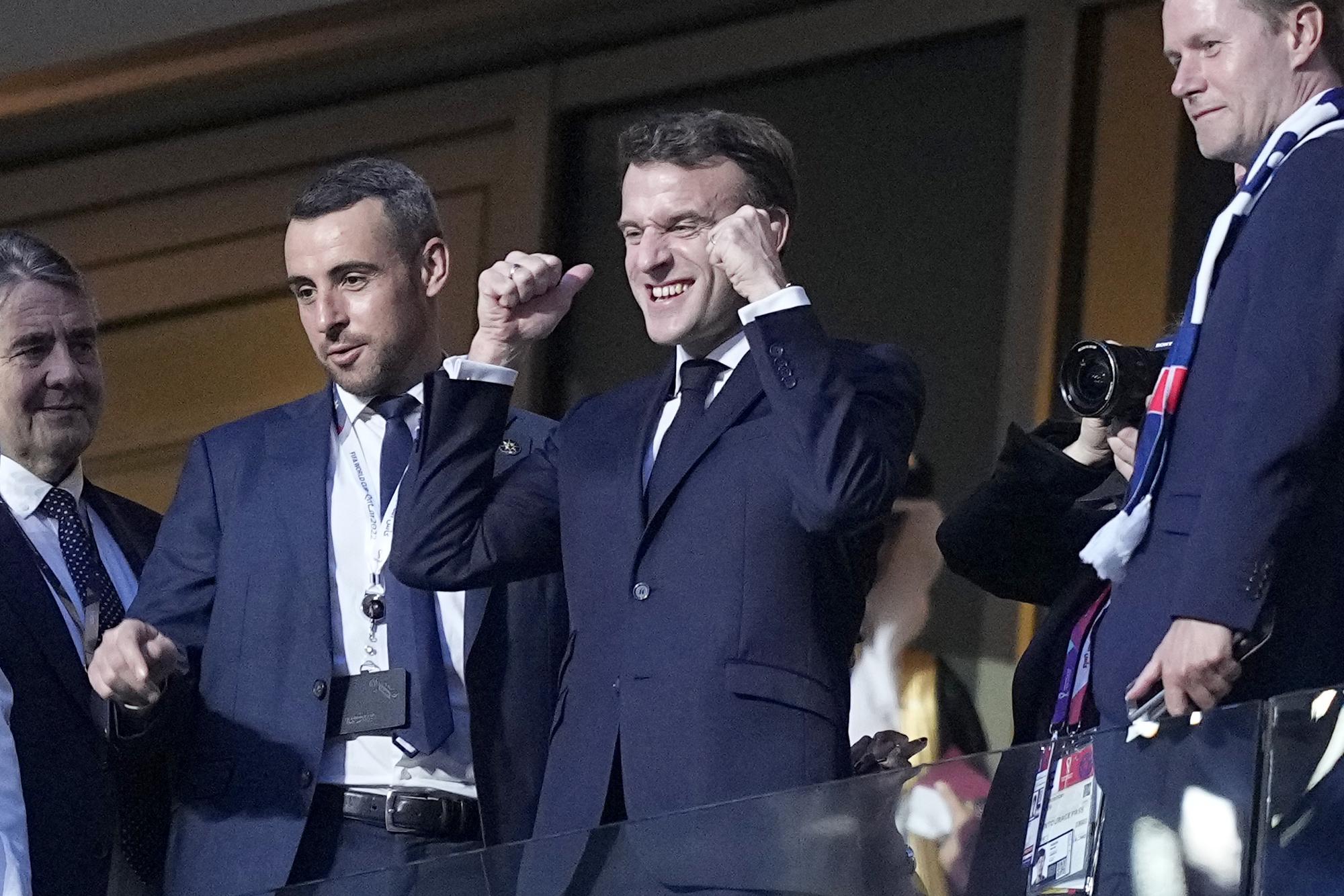 France's President Emmanuel Macron, center, gestures as he arrives on the tribune ahead of the World Cup final.