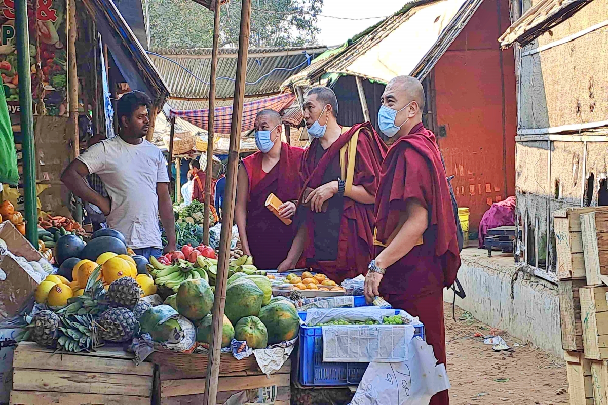 विदेशी फलों की दुकान पर खरीदारी करते बौद्ध श्रद्धालु