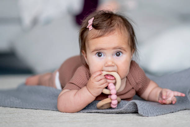 Little baby girl playing with a toy on the floo