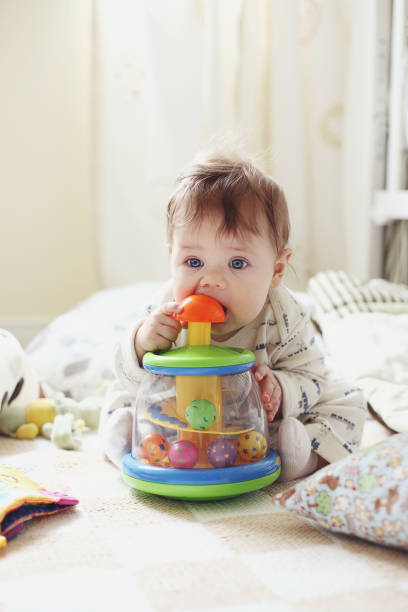 Little baby girl playing with a toy on the floo