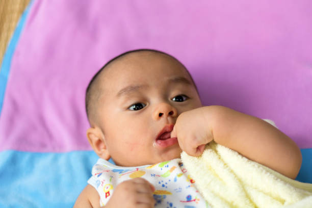 newborn baby suck finger on the bed