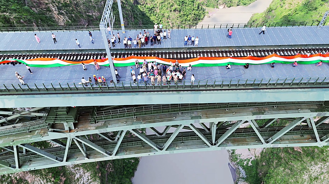 People take part in a Tiranga rally carrying a 750 m long tricolour, on the World's highest railway bridge on Chenab river on Aug 13, 2024.