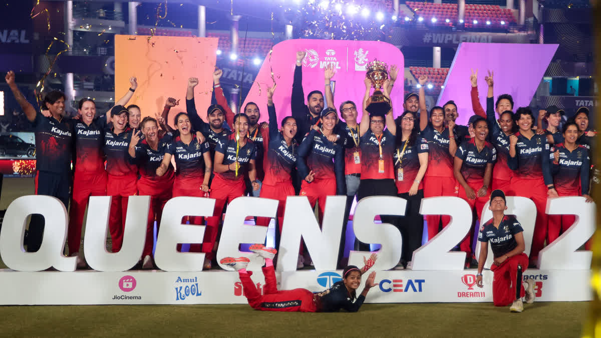 Royal Challengers Bangalore players pose with the winning trophy after they won the WPL final match against Delhi Capitals at the Arun Jaitley Stadium in New Delhi on Sunday, March 17, 2024.