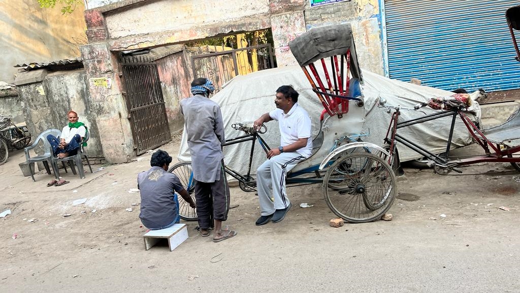 रिक्शा चालक से बातचीत करते अधिकारी