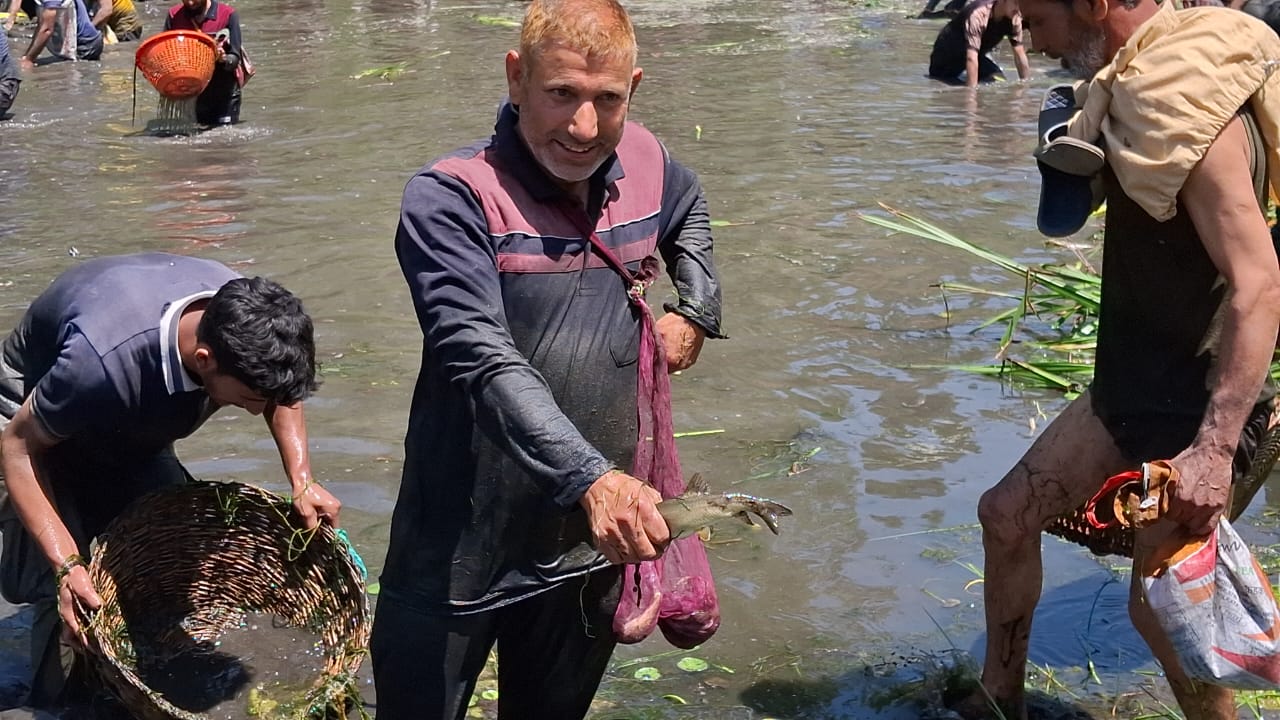 Locals from Panzath and adjoining villages plunge into the spring waters with wicker baskets and bags to clean the water body from pollutants.