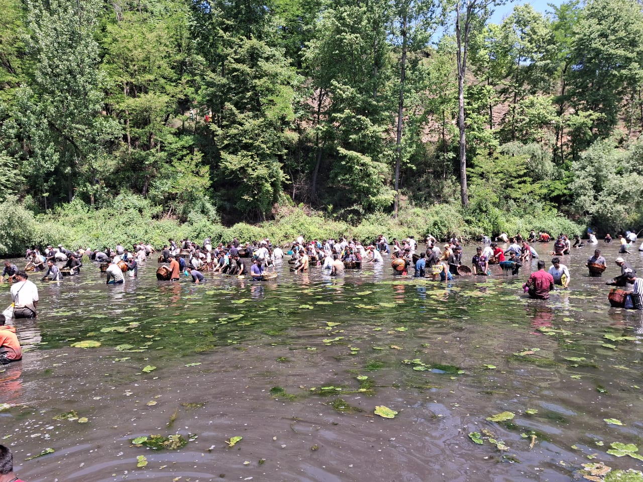 Locals from Panzath and adjoining villages plunge into the spring waters with wicker baskets and bags to clean the water body from pollutants.