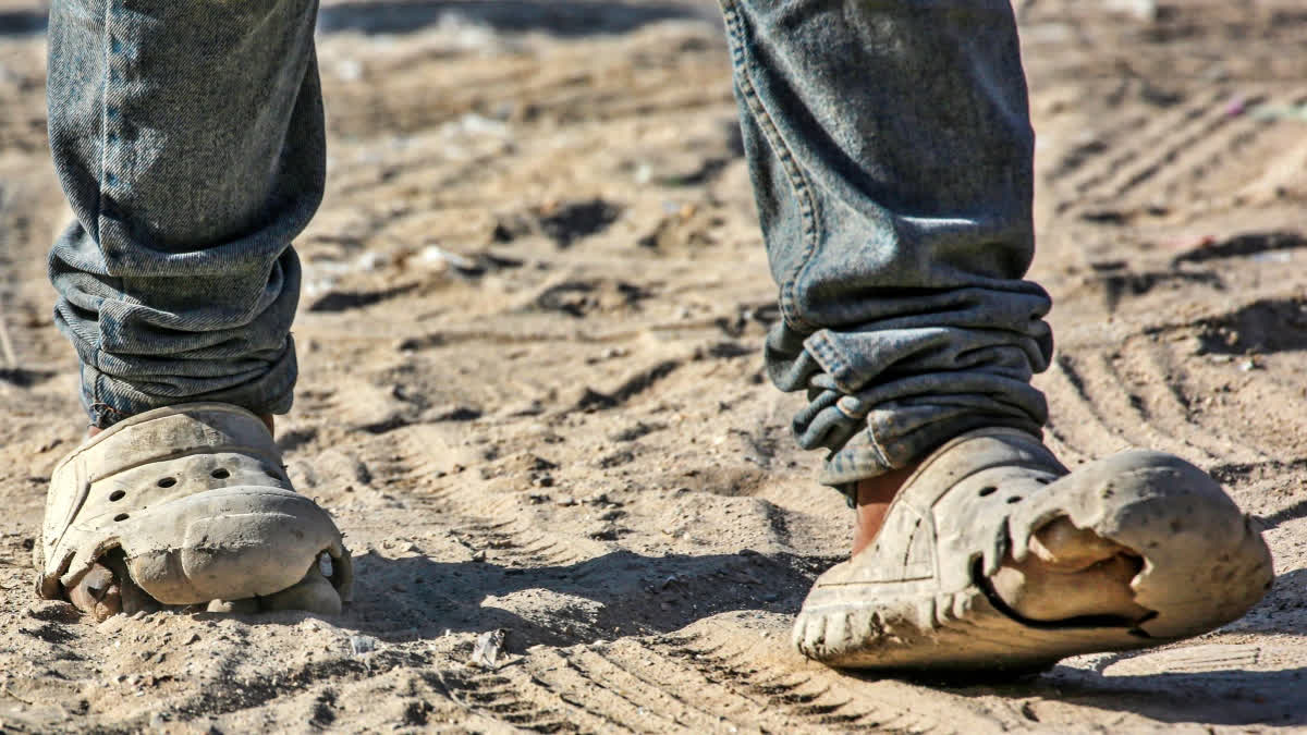 A Palestinian walks in damaged shoes in Khan Yunis, on the southern Gaza Strip on July 6, 2024, amid the ongoing conflict between Israel and the militant Hamas group. Finding shoes and clothing has become increasingly difficult for the 2.4 million people living in the Palestinian territory besieged by Israel.