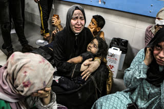 Wounded Palestinians sit in al-Shifa hospital in Gaza City, central Gaza Strip, after arriving from al-Ahli hospital following an explosion there, Tuesday, Oct. 17, 2023. The Hamas-run Health Ministry says an Israeli airstrike caused the explosion that killed hundreds at al-Ahli, but the Israeli military says it was a misfired Palestinian rocket. (AP Photo/Abed Khaled)