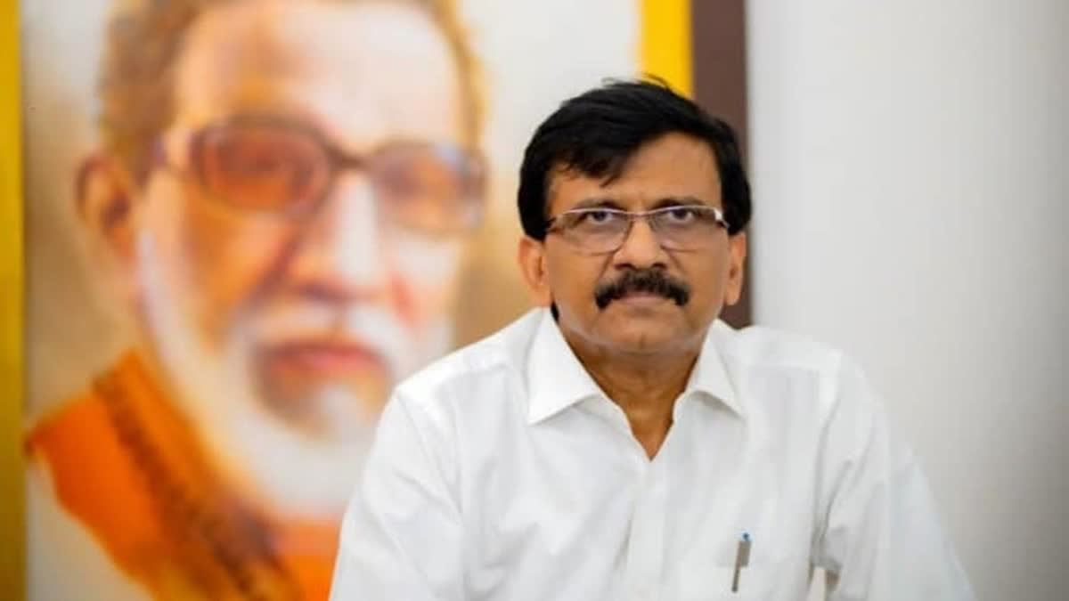 Shiv Sena Uddhav Balasaheb Thackeray leader Sanjay Raut in front of a portrait of Bal Thackeray