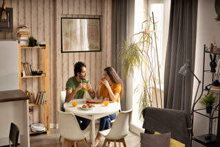 Couple sitting inside a busy looking house