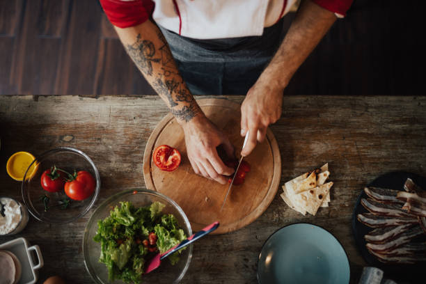 Chef uses the knife to slice tomato