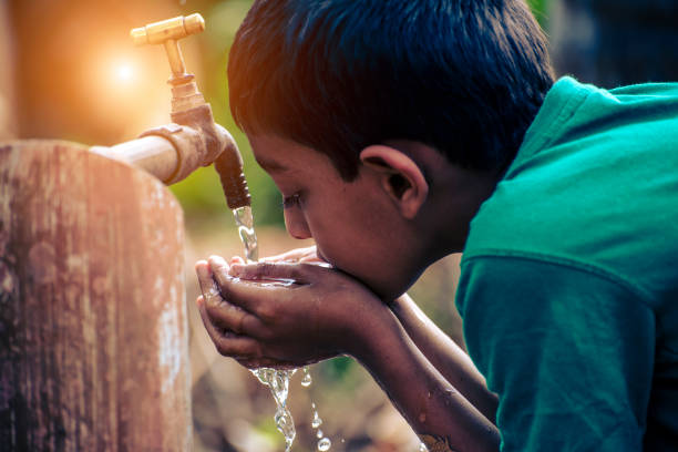 A boy drinking water from tap