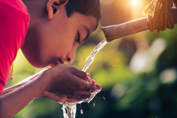 A boy drinking water from tap