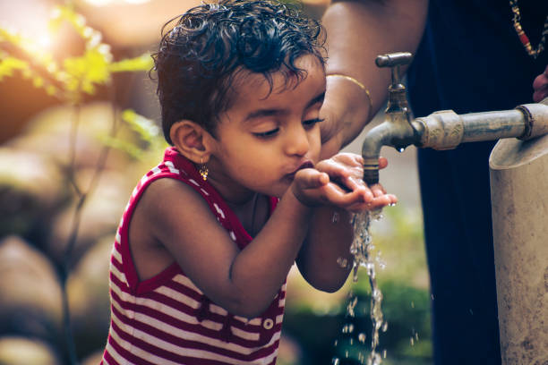 cute boy drinking water from tap