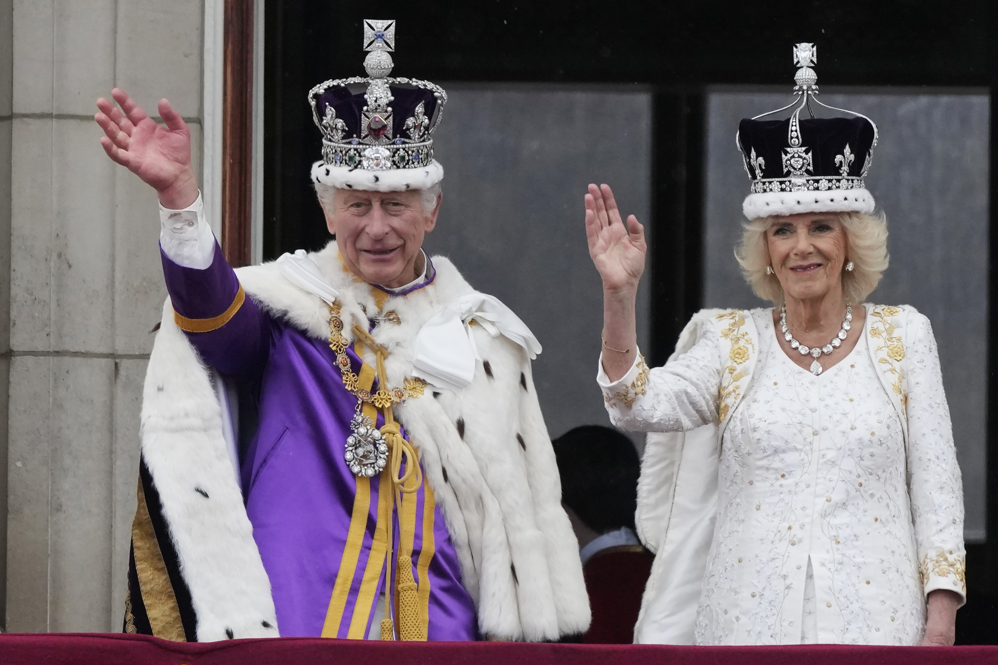 King Charles III and Queen Camilla wave to the crowds from the balcony of Buckingham Palace after the coronation ceremony in London on May 6, 2023