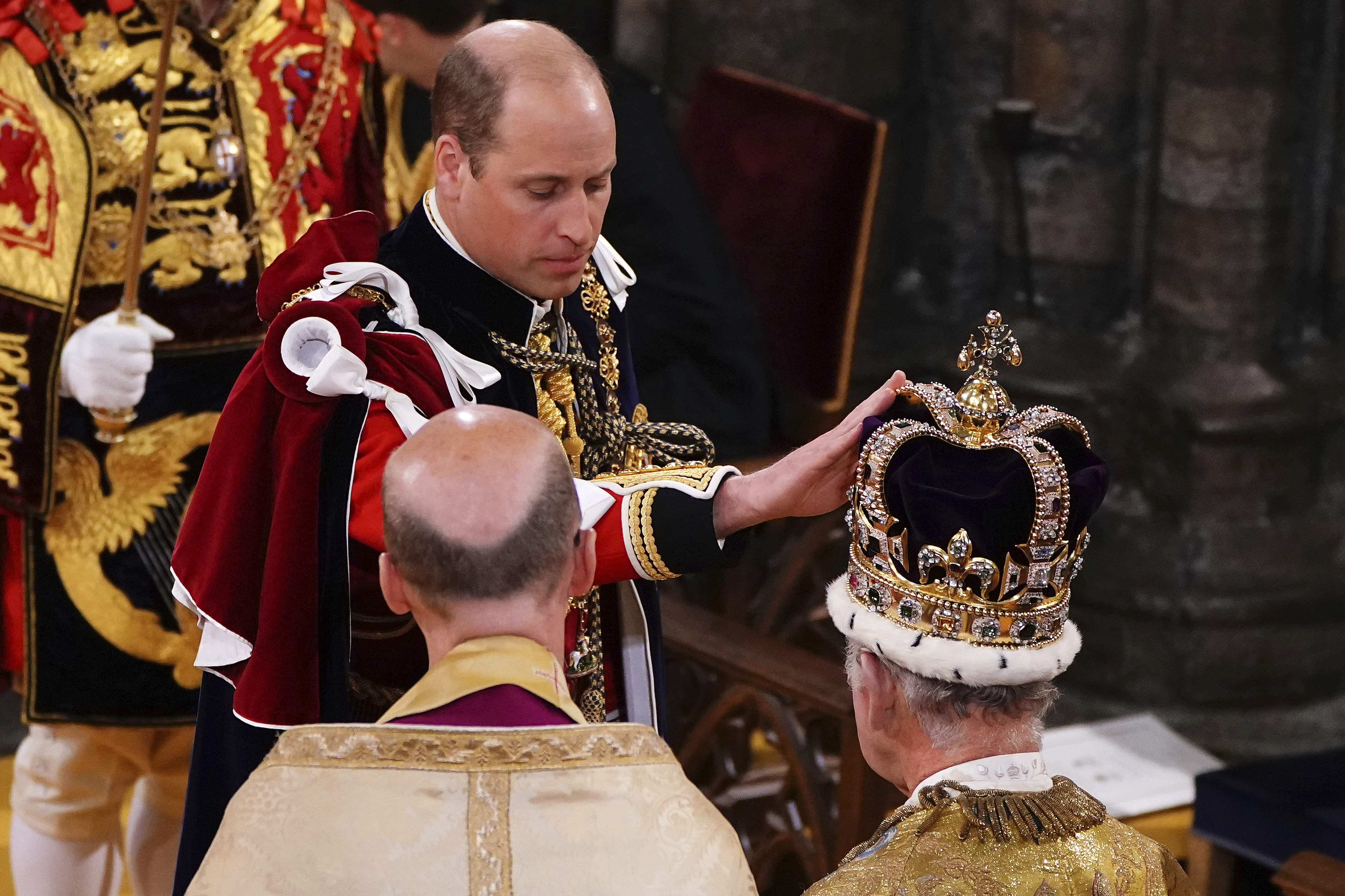 Britain's Prince William touches St Edward's Crown on King Charles III's head during his coronation ceremony