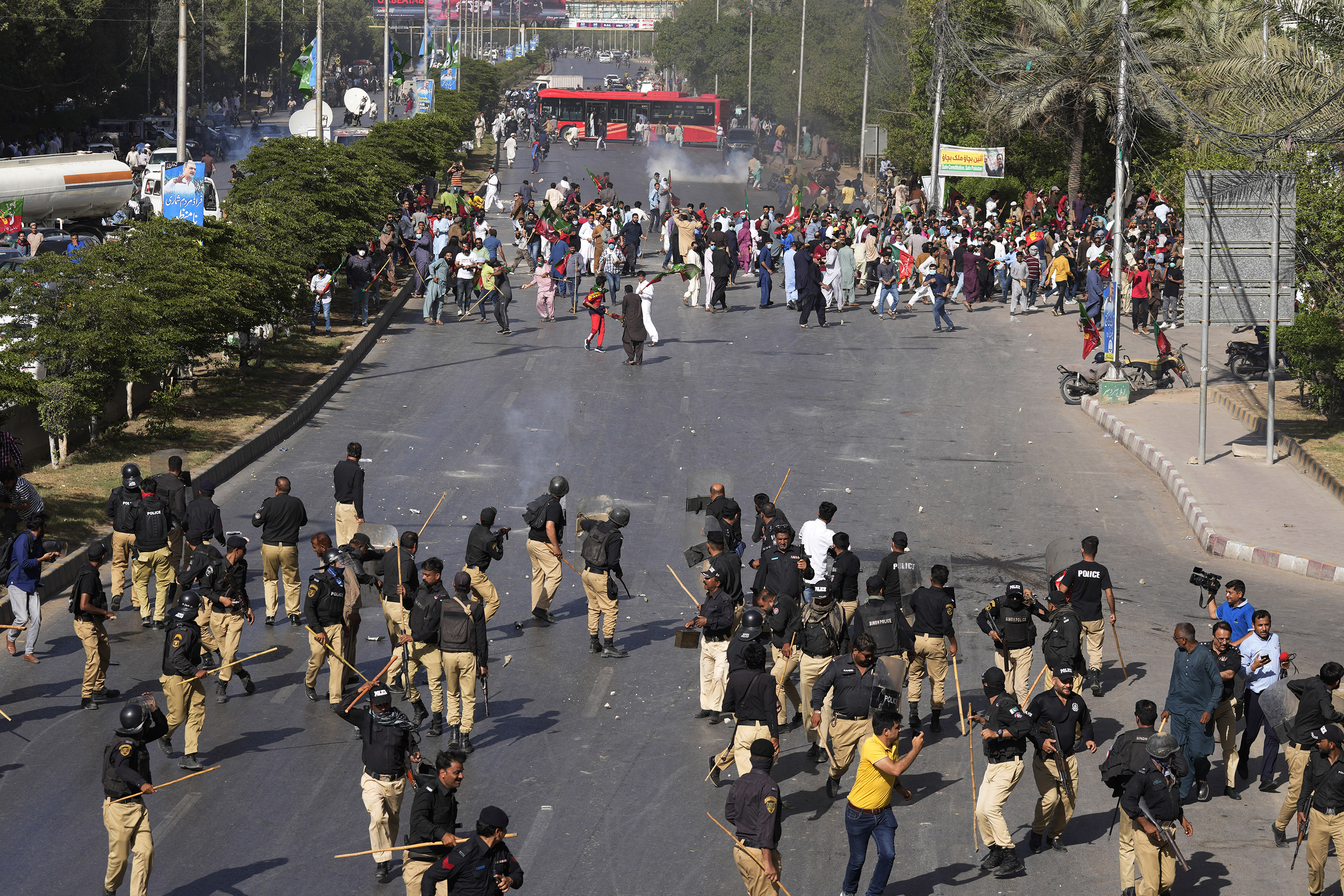 Police officers and supporters of Pakistan's former Prime Minister Imran Khan exchange stones during a protest against the arrest of Khan, in Karachi